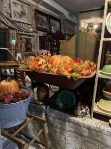 Seasonal Decor at Vintage Shops antique wheel barrow, old school desk some fall leaves and pumpkins